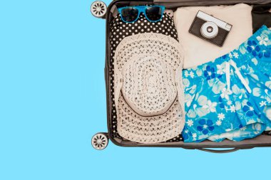 Mavi arka planda gezgin bavulu