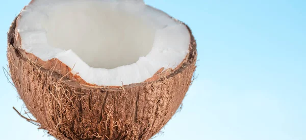 Een Halve Kokosnoot Tegen Een Helderblauwe Lucht — Stockfoto