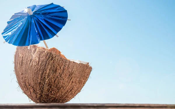 Kokosnuss Mit Regenschirm Vor Blauem Himmel — Stockfoto