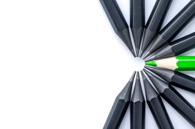 Beyaz arka planda bir yeşil kalem ve siyah kalem.