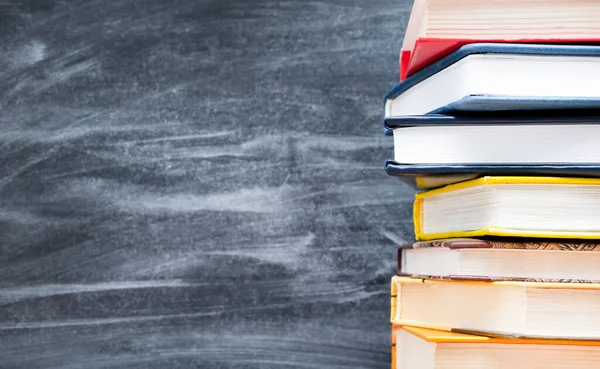 Karanlık bir arkaplanda kitap yığını