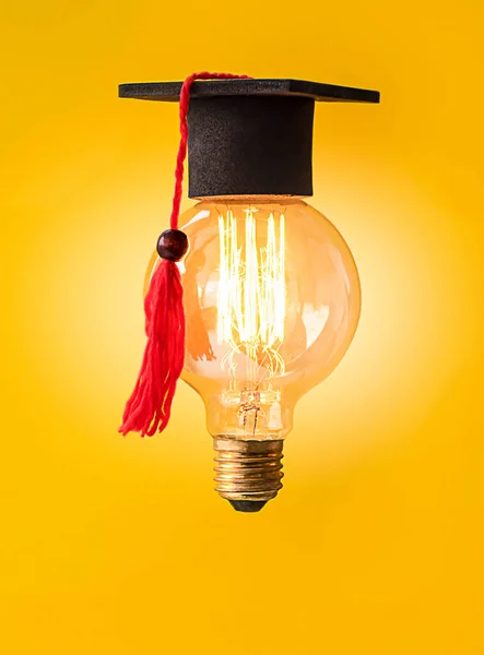 a burning light bulb in a graduate cap