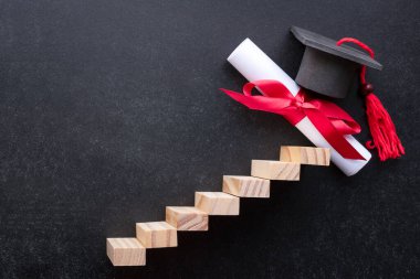 siyah arka planda mezuniyet şapkası olan merdiven ve diploma