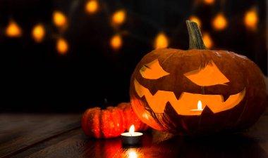 balkabakları ve mumlar koyu bir arka planda. Cadılar Bayramı için dekorasyonlar.