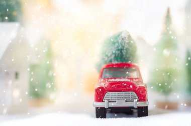 Arkasında Noel ağacı olan kırmızı bir araba.