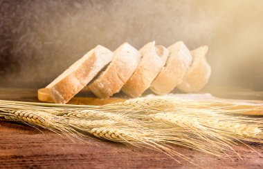 Tahta bir masanın üzerinde bir dilim ekmek ve buğday.