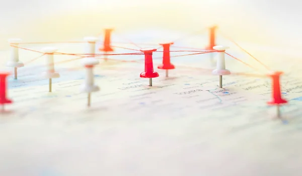 the thumbtacks on the road map are connected by threads. business concept