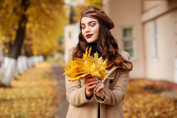 Strauß gelber Ahornblätter in den schönen Händen der Frauen. — Stockfoto