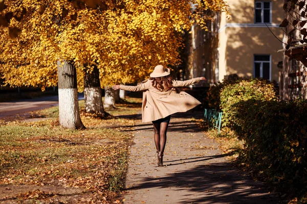 Modische Frau läuft im Herbst über die Straße. Mantel wedelt. — Stockfoto