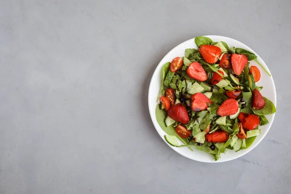 一盘新鲜的素食沙拉,背景是灰色的草莓.复制空间. — 图库照片