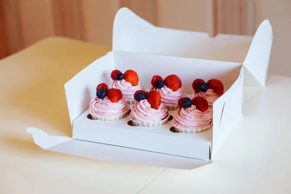 Deliciosos cupcakes cremosos com bagas em caixa de entrega branca. Entrega de sobremesas. — Fotografia de Stock