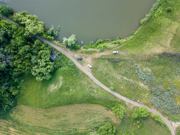Aerial drone view. Cars on the shore of a rural lake.