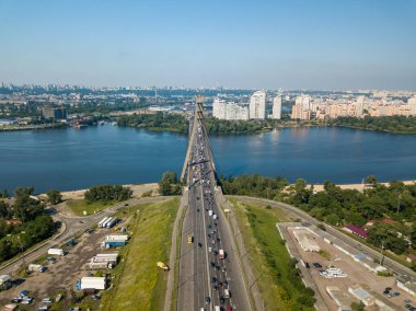 Hava aracı görüntüsü. Arabalar Kiev 'deki Dinyeper Nehri üzerinden Kuzey Köprüsü boyunca seyahat ederler. Yaz güneşli bir gün.
