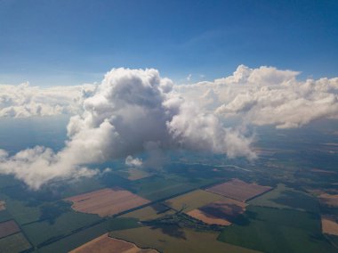 Yaz mevsiminde tarımsal tarlalar üzerinde bulutlarda yüksek uçuş.