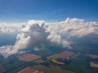 Yaz mevsiminde tarımsal tarlalar üzerinde bulutlarda yüksek uçuş.