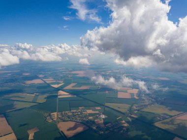 Yaz mevsiminde tarımsal tarlalar üzerinde bulutlarda yüksek uçuş.