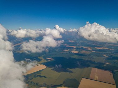 Yaz mevsiminde tarımsal tarlalar üzerinde bulutlarda yüksek uçuş.