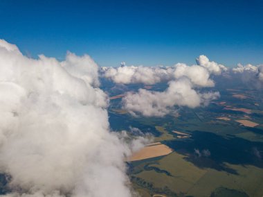 Yaz mevsiminde tarımsal tarlalar üzerinde bulutlarda yüksek uçuş.