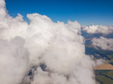 Yaz mevsiminde tarımsal tarlalar üzerinde bulutlarda yüksek uçuş.