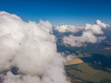 Yaz mevsiminde tarımsal tarlalar üzerinde bulutlarda yüksek uçuş.