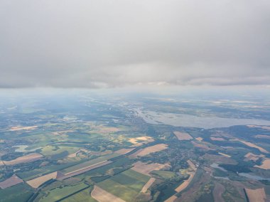 Yaz mevsiminde tarımsal tarlalar üzerinde bulutlarda yüksek uçuş.