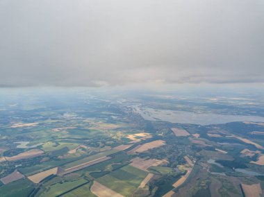 Yaz mevsiminde tarımsal tarlalar üzerinde bulutlarda yüksek uçuş.