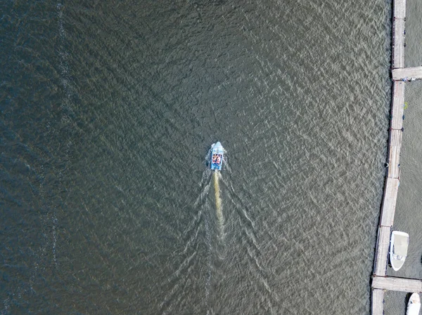 Motorlu tekne nehir boyunca yelken açar. Hava aracı görünümü.