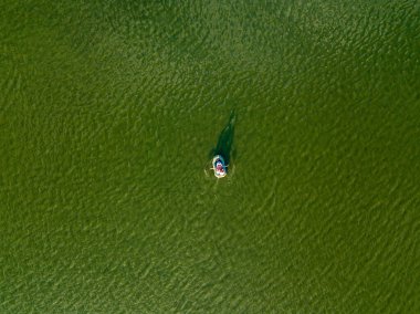 Hava aracı görüntüsü. Nehrin yeşil sularında balıkçı teknesi.