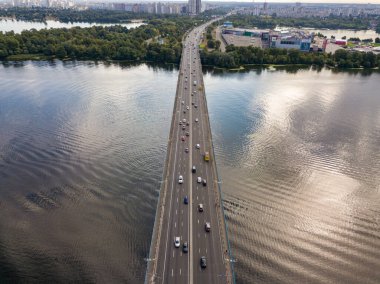 Hava aracı görüntüsü. Arabalar Kiev 'deki Dinyeper boyunca Kuzey Köprüsü boyunca ilerliyor..