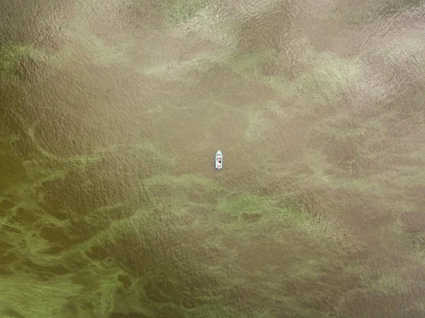 空中ドローンビュー 水の上に漁船 水の中に藻が咲き 雲が反映されます — ストック写真