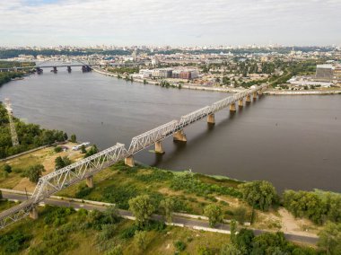 Hava aracı görüntüsü, tren nehir boyunca demiryolu köprüsü boyunca ilerliyor..