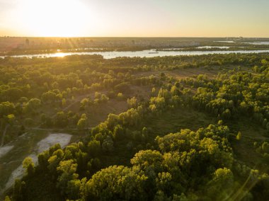 Hava aracı görüntüsü. Akşam Kiev 'deki Dinyeper Nehri kıyısında batan güneşin altında.
