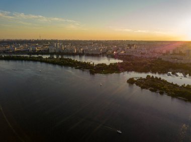 Hava aracı görüntüsü. Akşam Kiev 'deki Dinyeper Nehri kıyısında batan güneşin altında.