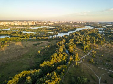 Hava aracı görüntüsü. Gün batımında şehrin dışındaki çayırların arasındaki ağaçlar..