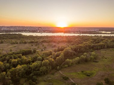 Hava aracı görüntüsü. Dinyeper Nehri ve Kiev şehrinin üzerinde gün batımı.