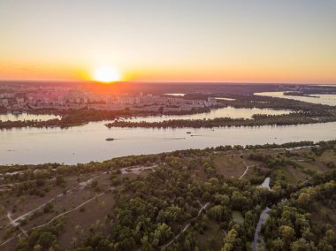Hava aracı görüntüsü. Dinyeper Nehri ve Kiev şehrinin üzerinde gün batımı.