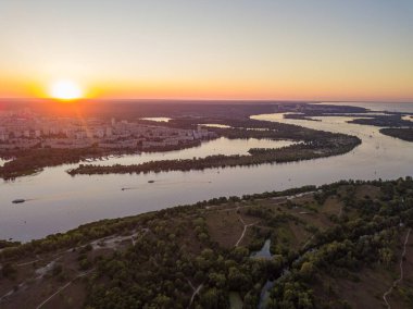 Hava aracı görüntüsü. Dinyeper Nehri ve Kiev şehrinin üzerinde gün batımı.