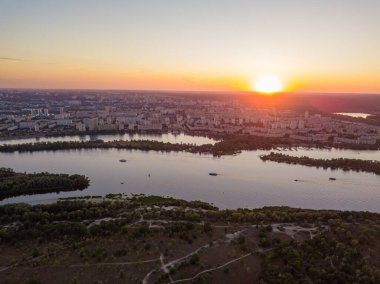 Hava aracı görüntüsü. Dinyeper Nehri ve Kiev şehrinin üzerinde gün batımı.