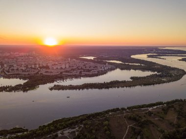 Hava aracı görüntüsü. Dinyeper Nehri ve Kiev şehrinin üzerinde gün batımı.