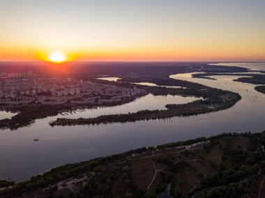 Hava aracı görüntüsü. Dinyeper Nehri ve Kiev şehrinin üzerinde gün batımı.