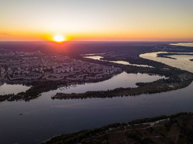 Hava aracı görüntüsü. Dinyeper Nehri ve Kiev şehrinin üzerinde gün batımı.