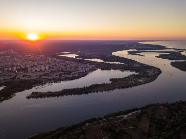 Hava aracı görüntüsü. Dinyeper Nehri ve Kiev şehrinin üzerinde gün batımı.