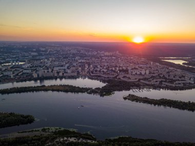 Hava aracı görüntüsü. Dinyeper Nehri ve Kiev şehrinin üzerinde gün batımı.