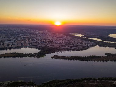 Hava aracı görüntüsü. Dinyeper Nehri ve Kiev şehrinin üzerinde gün batımı.