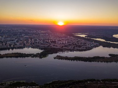 Hava aracı görüntüsü. Dinyeper Nehri ve Kiev şehrinin üzerinde gün batımı.