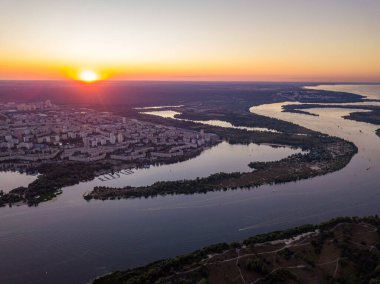 Hava aracı görüntüsü. Dinyeper Nehri ve Kiev şehrinin üzerinde gün batımı.