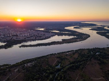 Hava aracı görüntüsü. Dinyeper Nehri ve Kiev şehrinin üzerinde gün batımı.