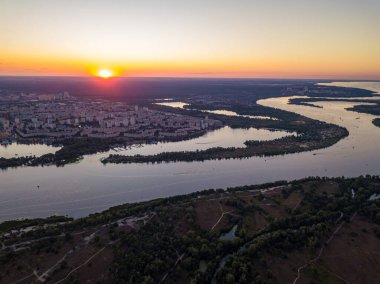 Hava aracı görüntüsü. Dinyeper Nehri ve Kiev şehrinin üzerinde gün batımı.
