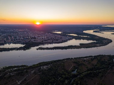 Hava aracı görüntüsü. Dinyeper Nehri ve Kiev şehrinin üzerinde gün batımı.