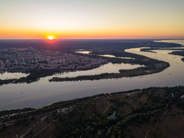 Hava aracı görüntüsü. Dinyeper Nehri ve Kiev şehrinin üzerinde gün batımı.